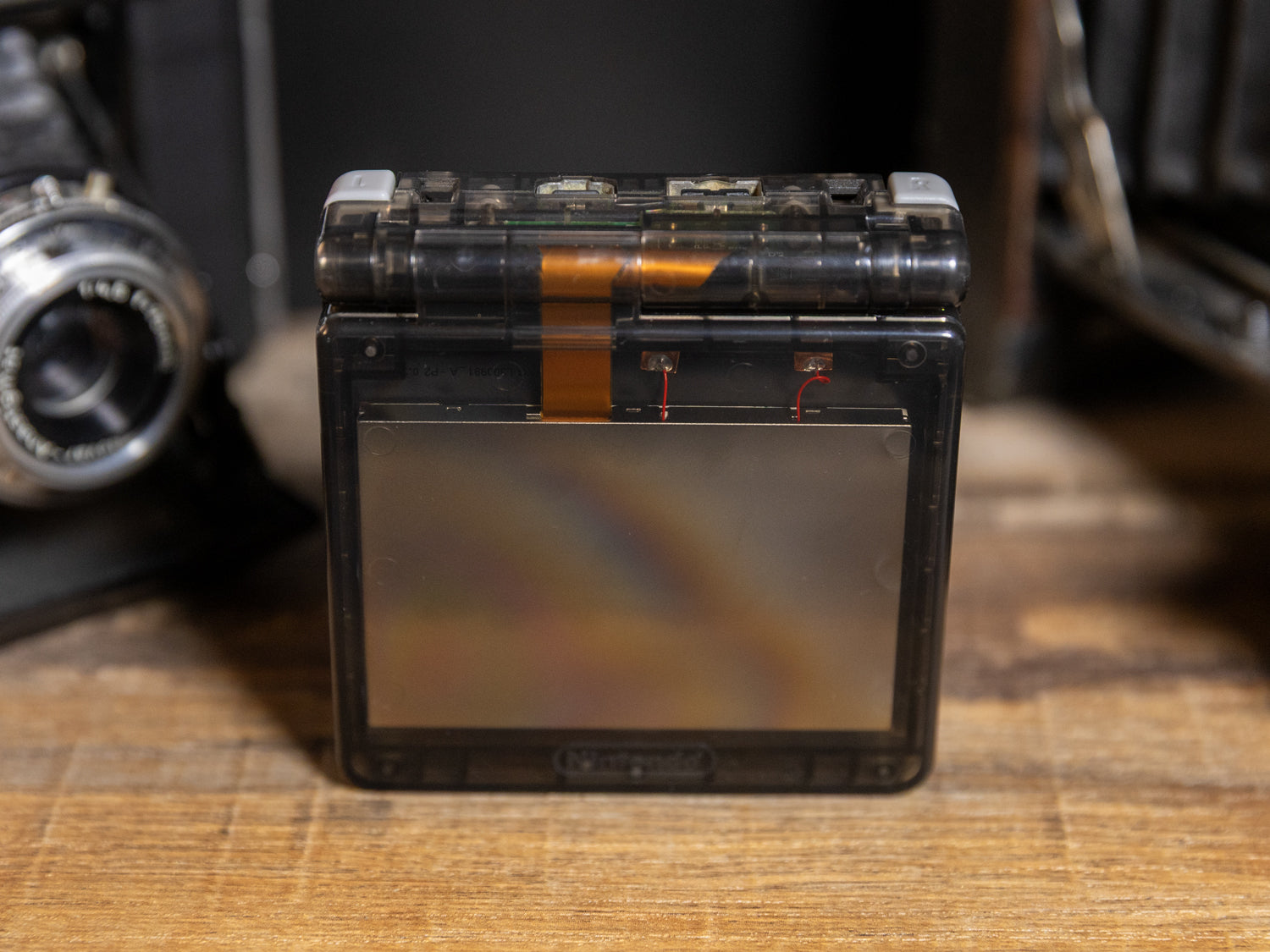 Game Boy Advance SP Transparent Black - Closed back view see-through smoke shell showing internal electronics