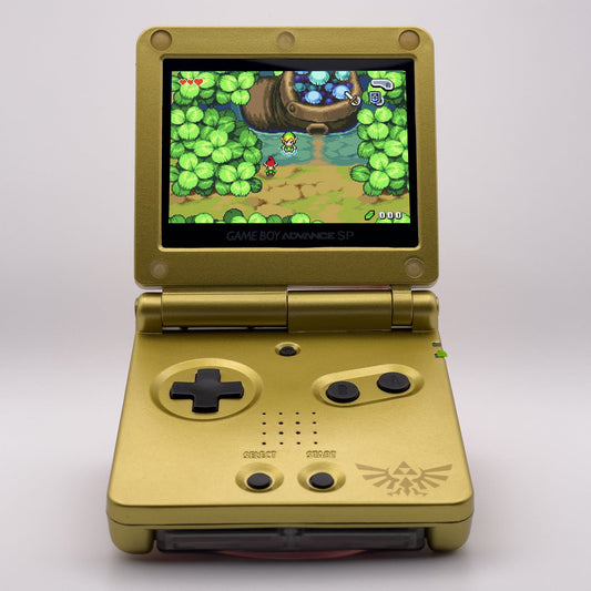 Gold handheld gaming console with a game displayed on the screen against a white background