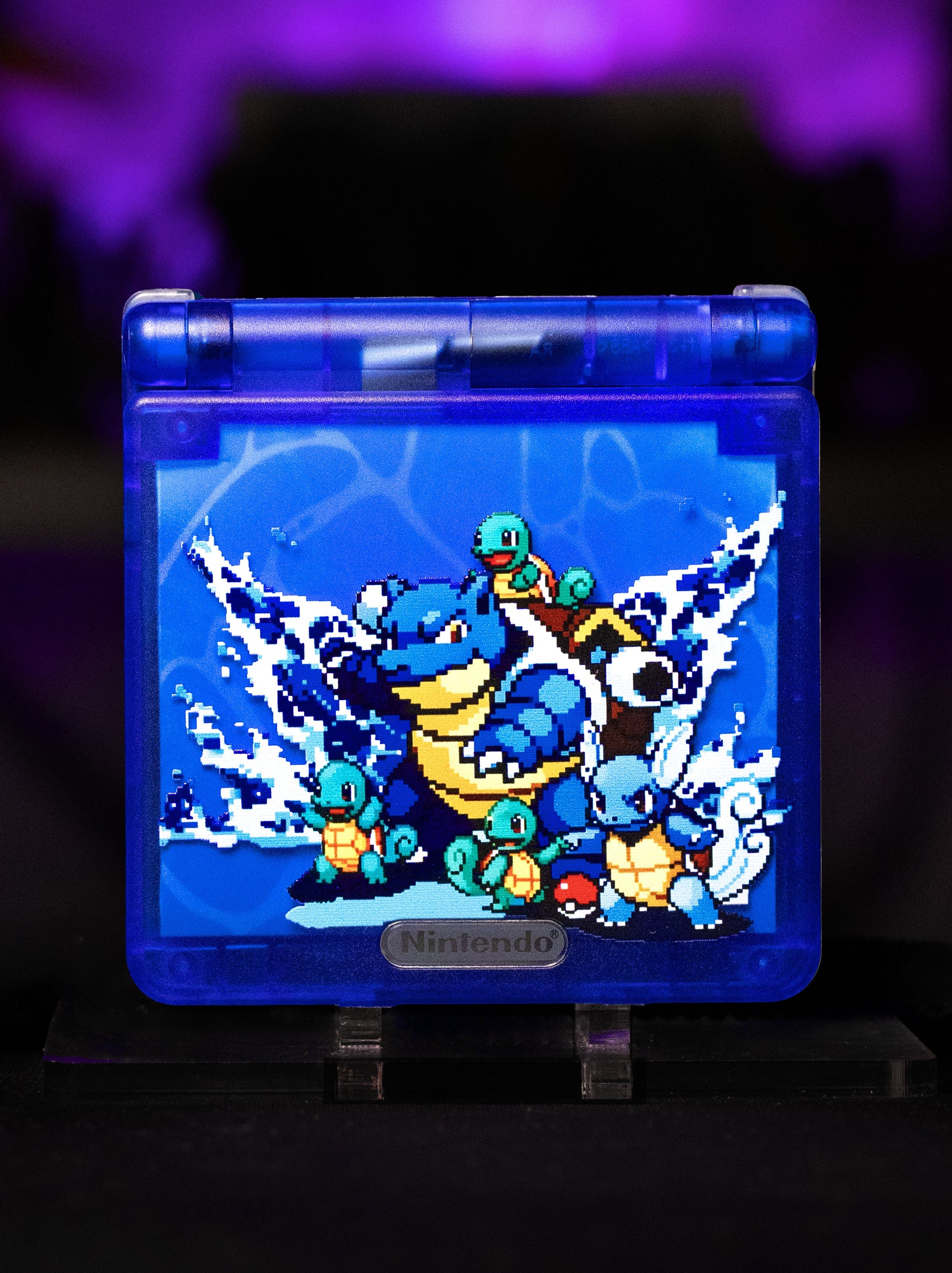 Blue Game Boy Advance case with a screen displaying a Pokémon design on a dark background